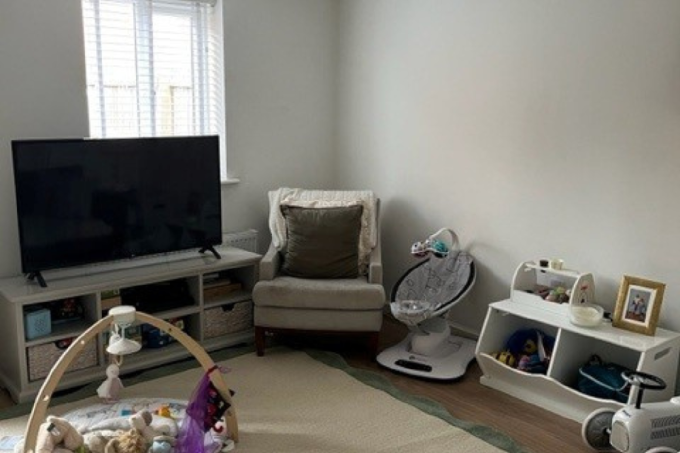 Living room with TV, chairs and cupboards.