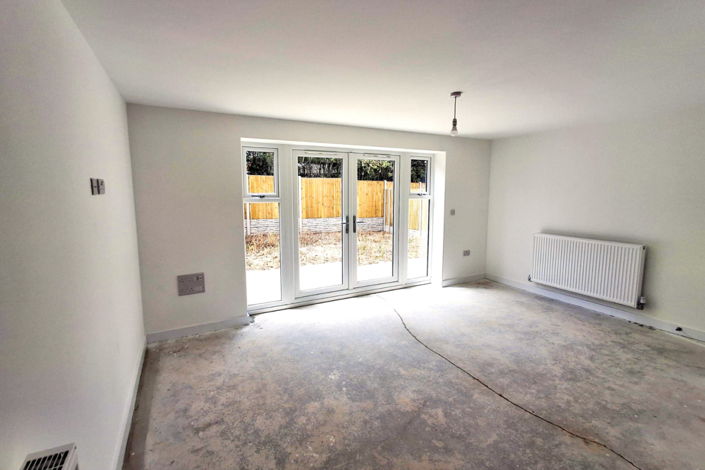 The lounge showing patio doors and a radiator
