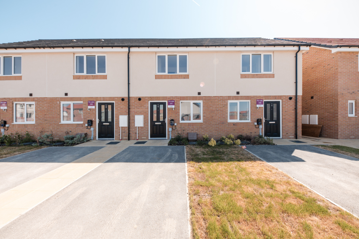 Front of a terraced row of houses with parking