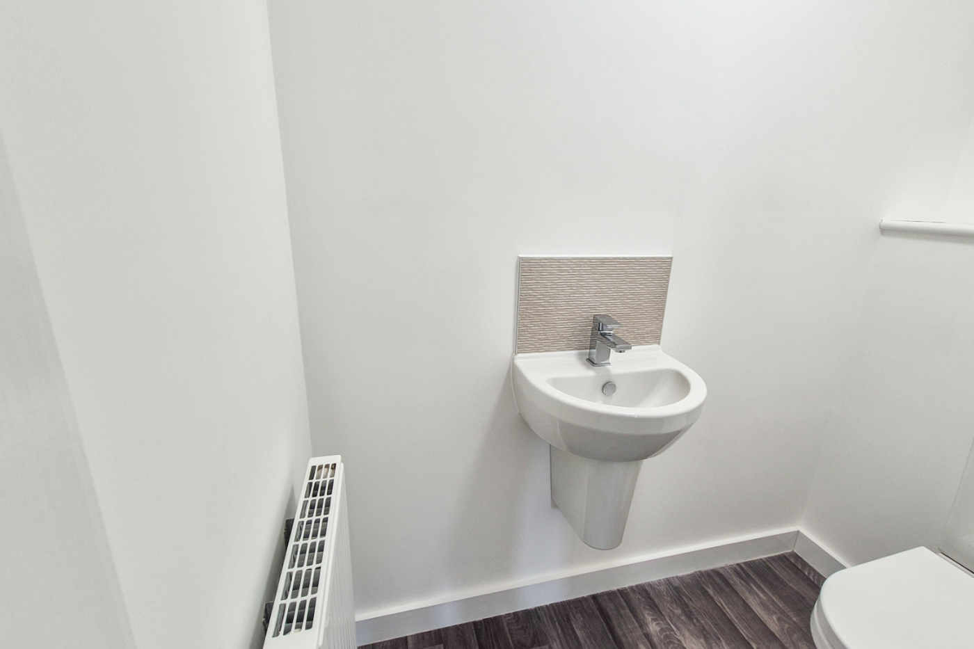 The downstairs water closet showing sink, toilet and radiator