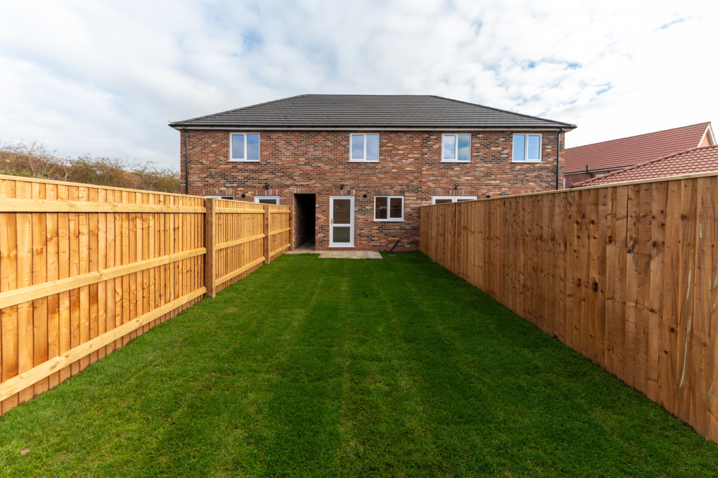 turfed garden looking towards a house