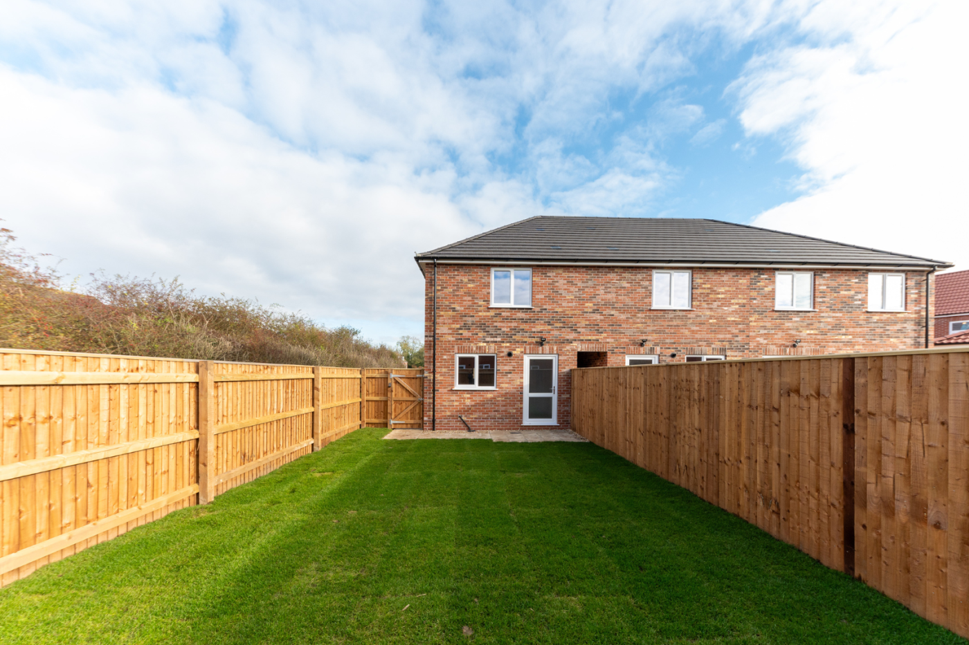 turfed garden looking towards a house