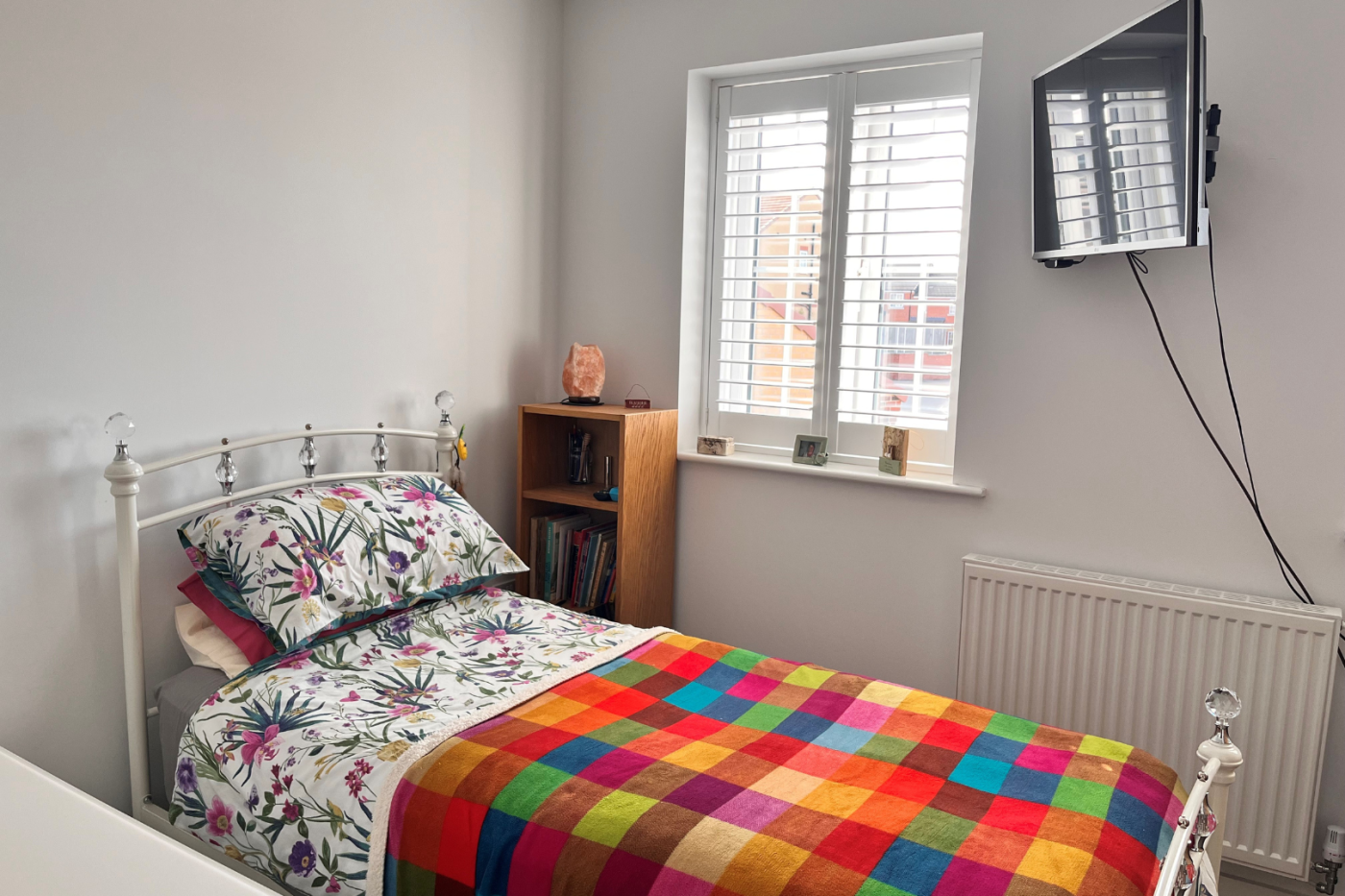 Single bed with a TV on the wall