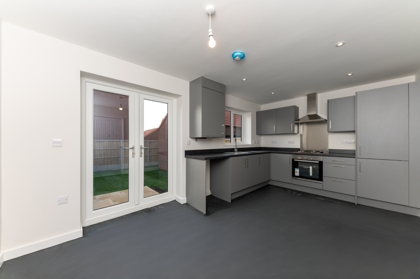 Kitchen diner with french doors out on to a turfed lawn