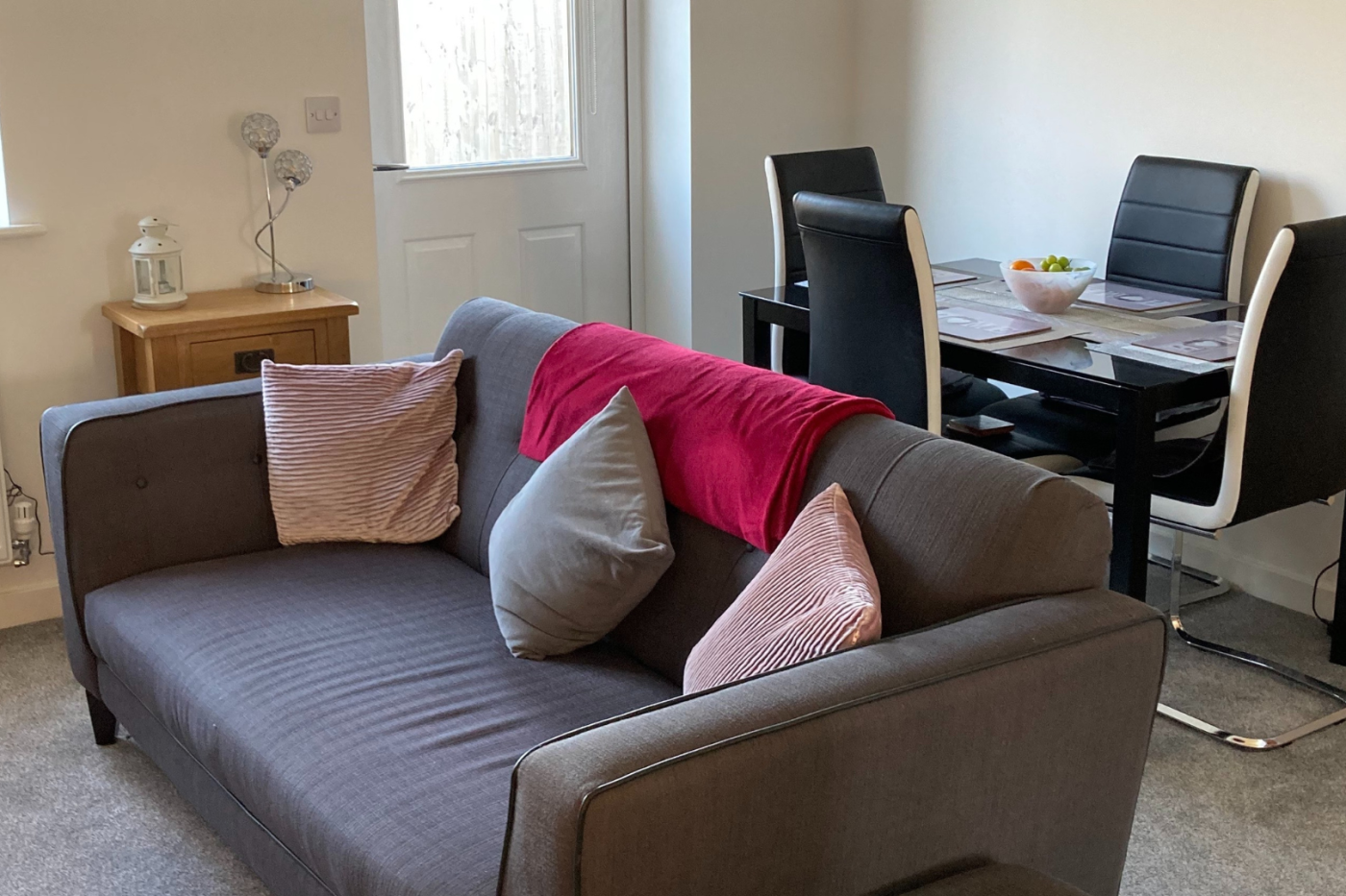 A picture of the living room showing a sofa and a dining table and chairs