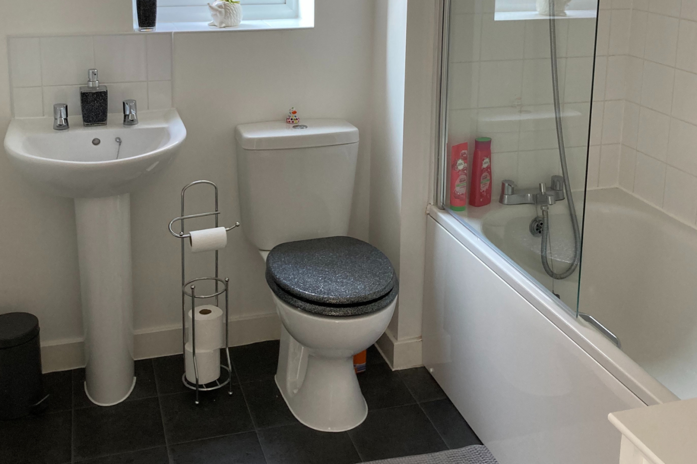 A photo of the upstairs bathroom showing a toilet, sink and shower
