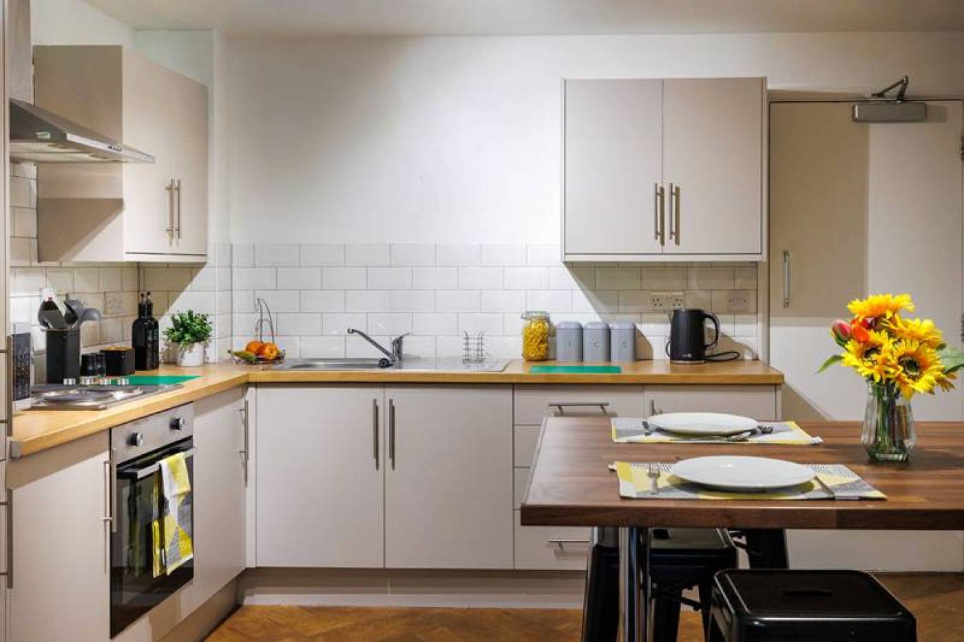 Shared kitchen with dining table and stools