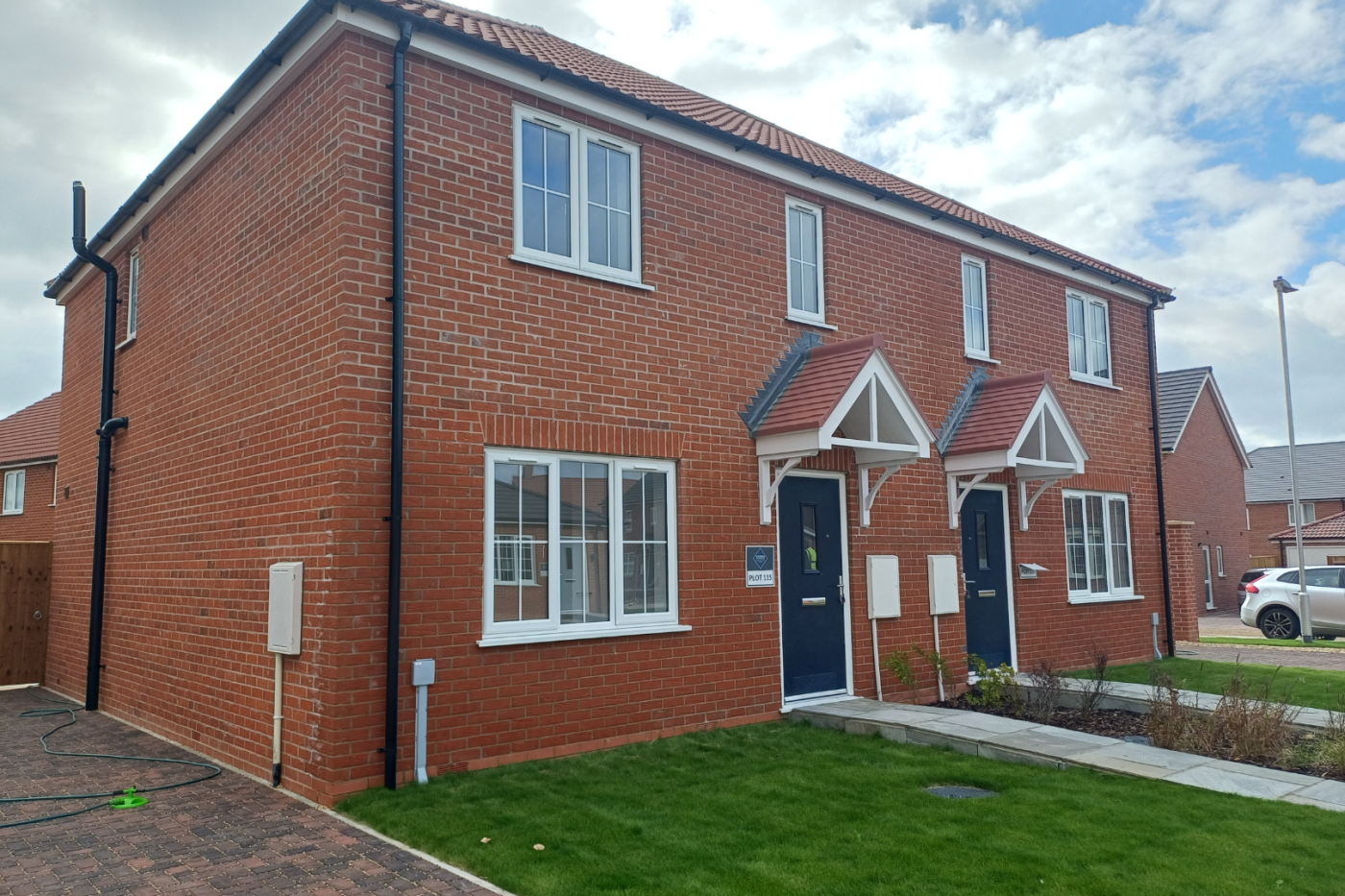 Side on of a semi detached house with parking and a garden at the front.