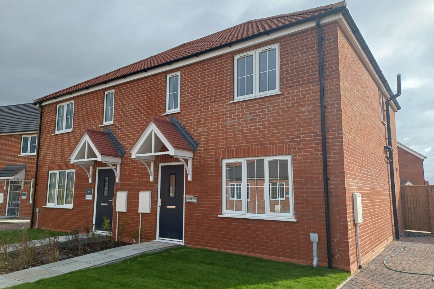 Side on of a semi detached house with parking and a garden at the front.