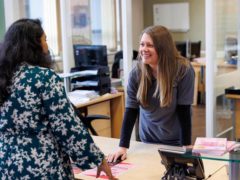 Two women chatting over desk