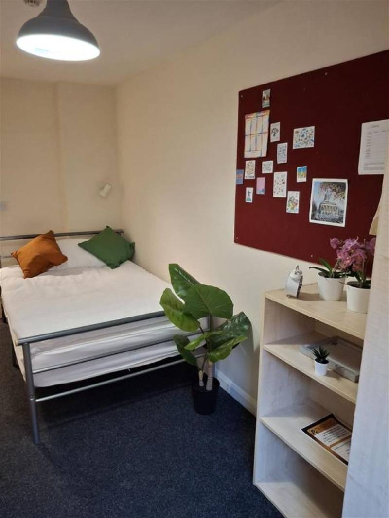 Bedroom with bed, wardrobe, desk and window