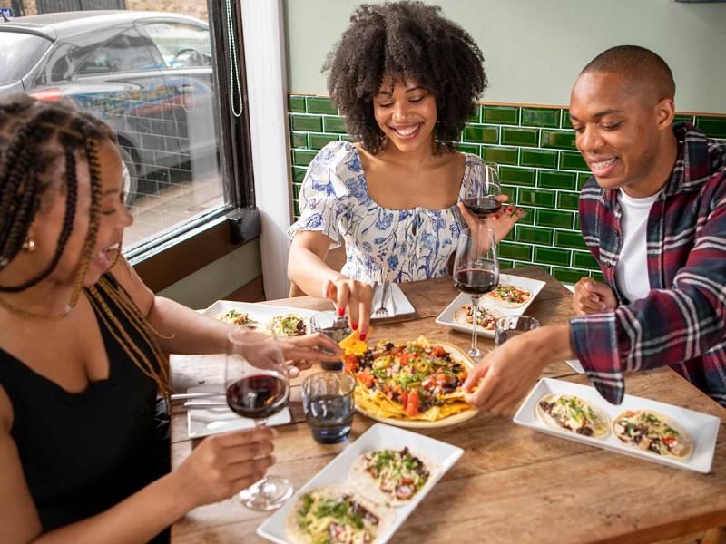 Students sharing food, laughing in a restuarant