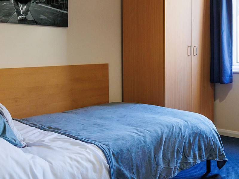 Bedroom with bed, wardrobe, desk and window