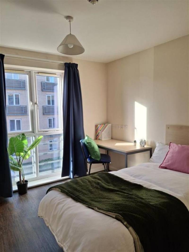 Bedroom with bed, wardrobe, desk and window