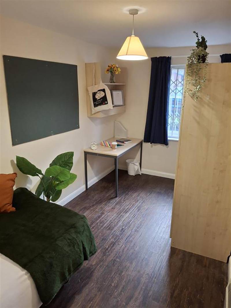 Bedroom with bed, shelving, desk and window