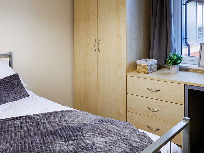 Student room with bed, desk and wardrobe