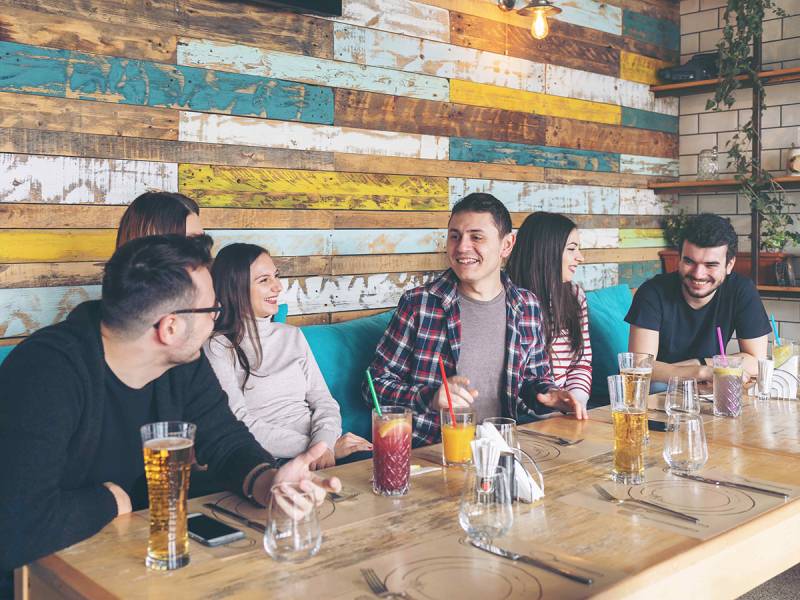 Students sharing food, laughing in a restuarant