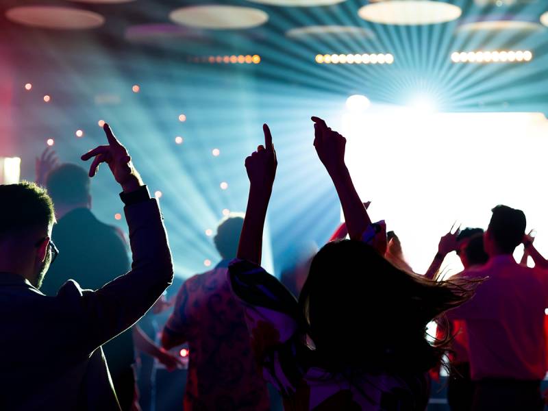 Bright nightclub lights with silhouettes of students dancing