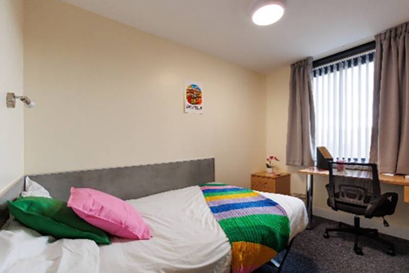 Bedroom with bed, desk and window