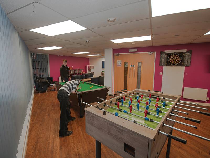 Students playing pool in common room
