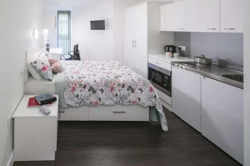 Studio room with bed, wardrobe, desk and kitchenette