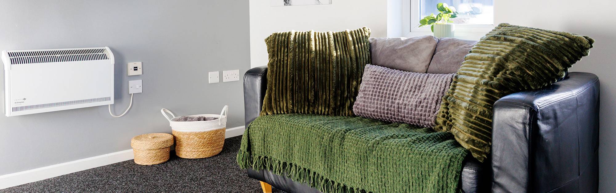 Apartment living area with leather sofa and large scatter cushions