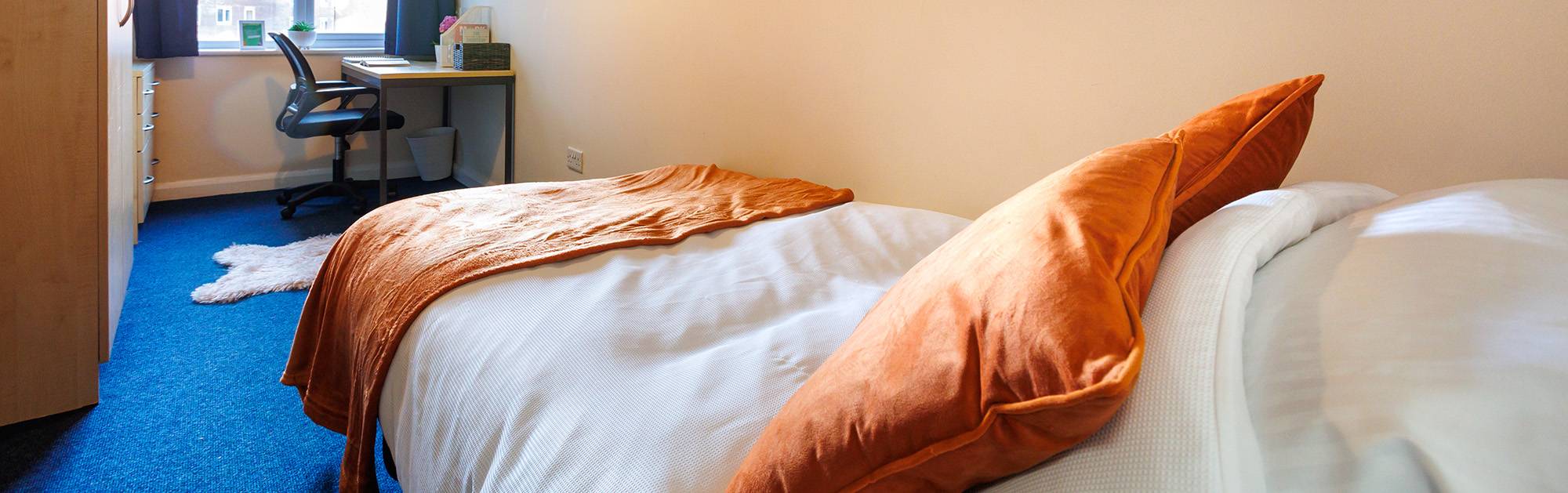 Student bedroom with bed, wardrobe and desk