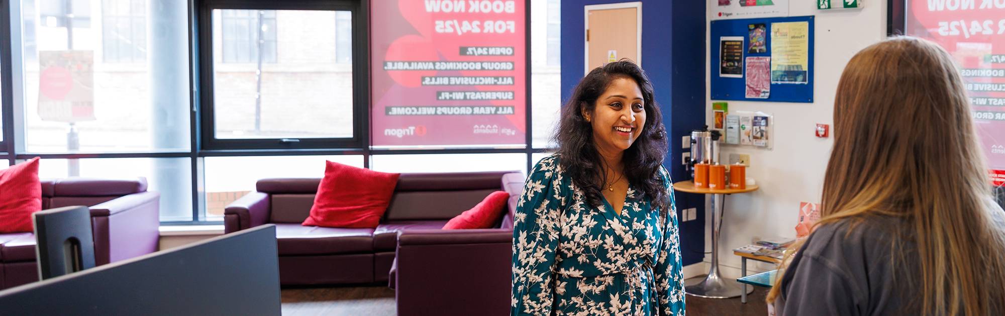 Two women chatting at support desk