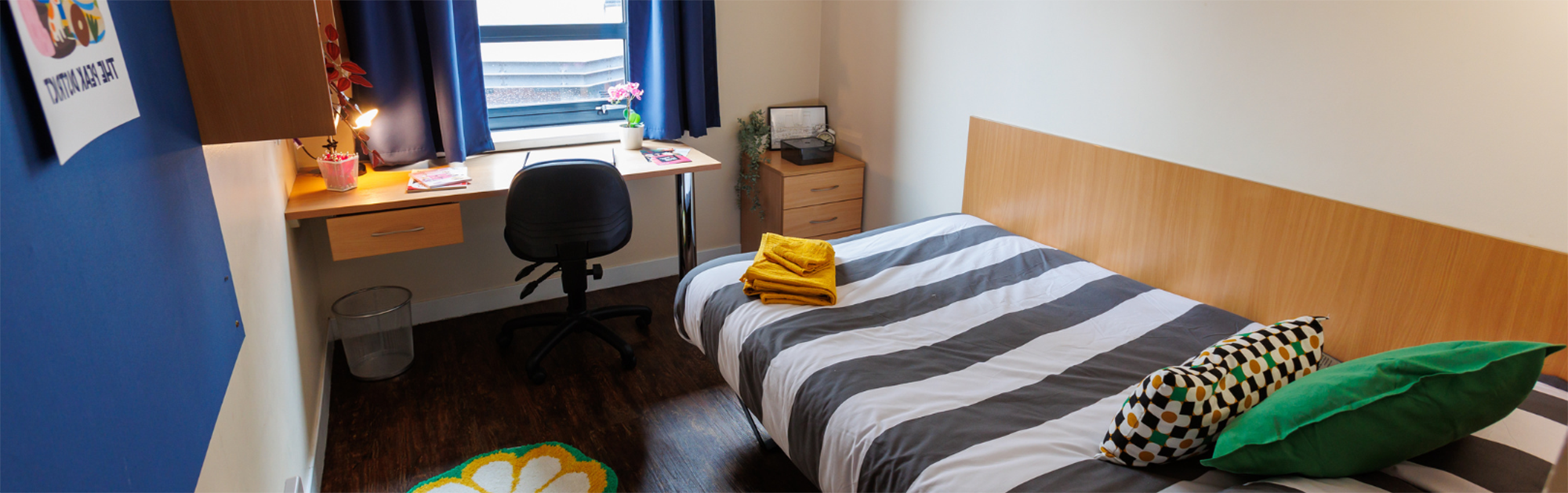 Single student accommodation room with bed, desk and window