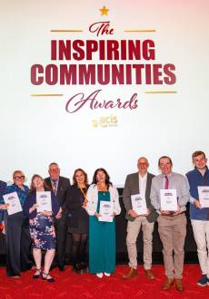 Group stood together smiling with awards and certificates
