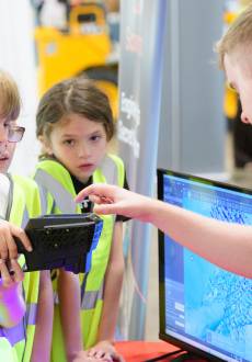 A group of children try using a laser scanner