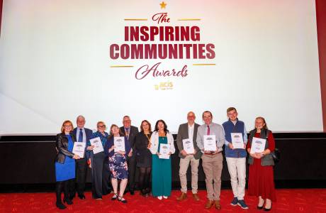 Group stood together smiling with awards and certificates