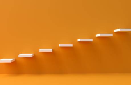 An orange wall with white stairs embedded in it 