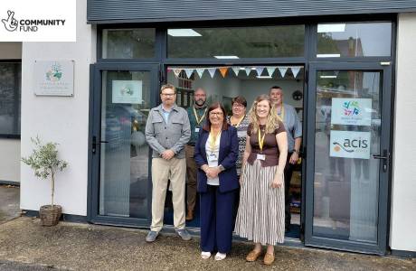 A group of staff smile as they stand outside of a new Wellbeing and Learning Hub