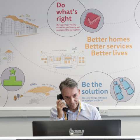 Man sitting behind a computer on the telephone