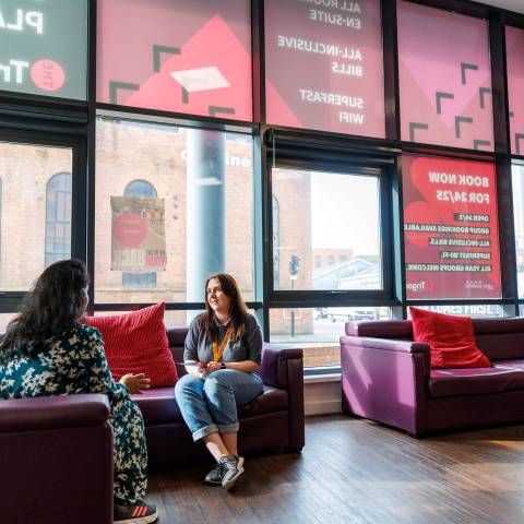 Two women sitting chatting in reception