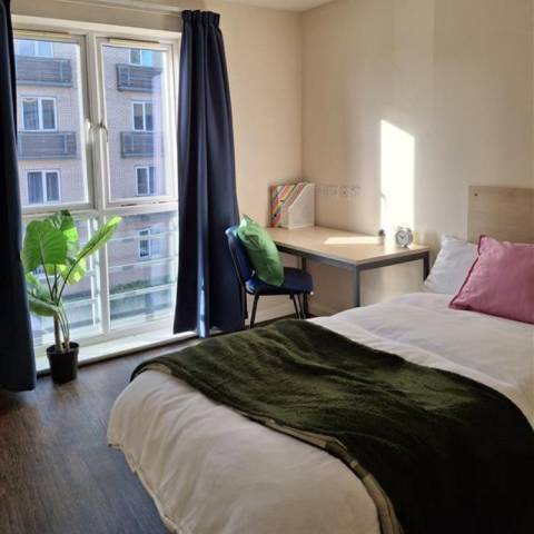 Bedroom with bed, desk and wardrobe