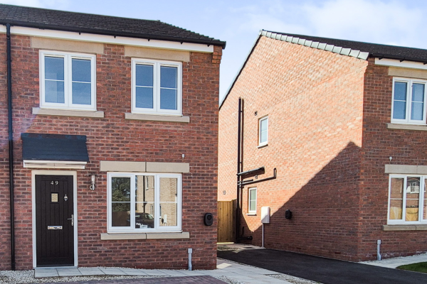 The front of the house showing the front door, three windows and two parking spaces