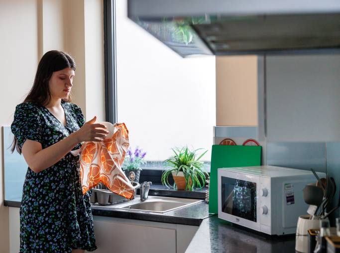 Women drying the dishes in a student kitchen