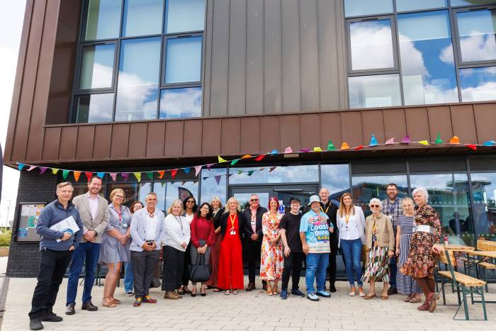 A group of people standing outside a modern community hub