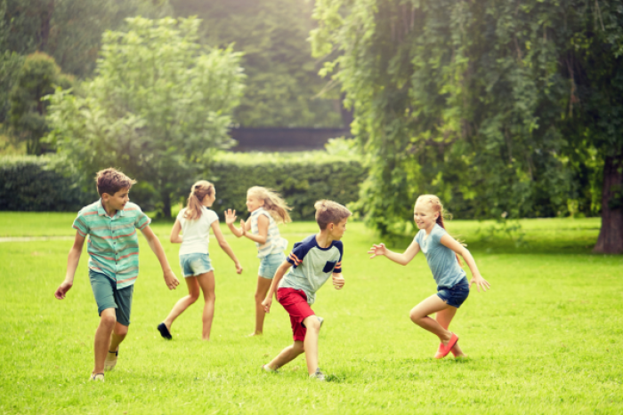 Children playing on a field in the sunshine