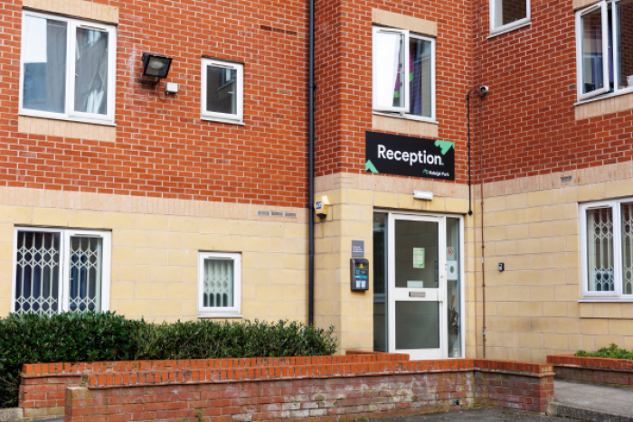 Image of an entranceway to a block of flats with a reception sign