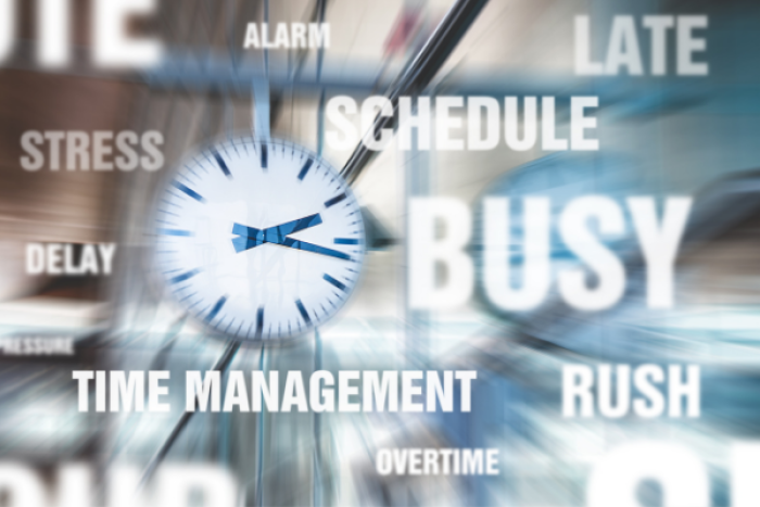 Clock with blurred background and text saying busy, time management, stress, delay