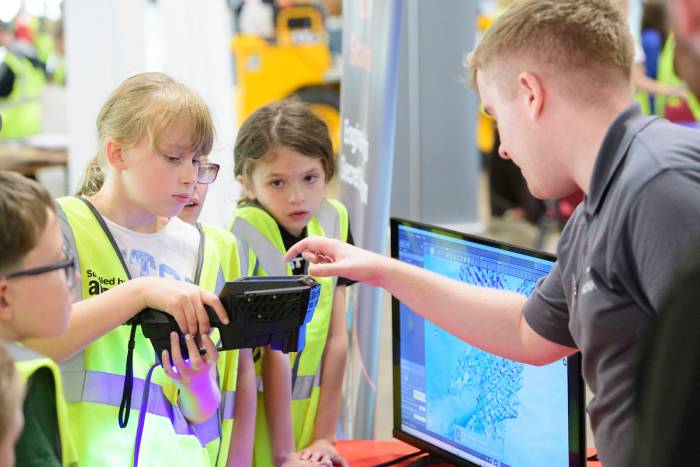A group of children try using a laser scanner