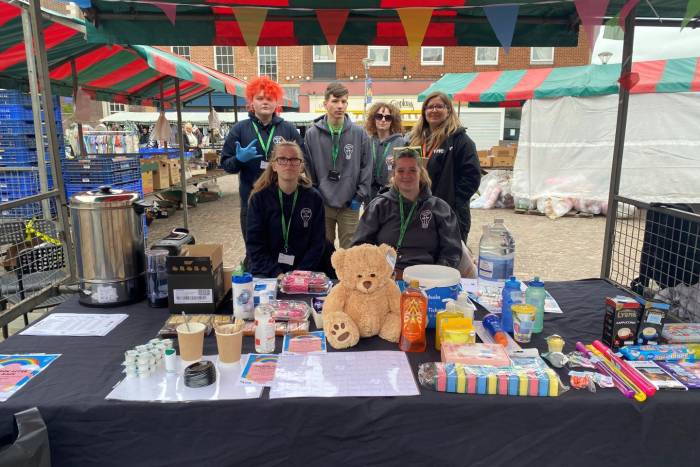 A group of people stood behind a market stall