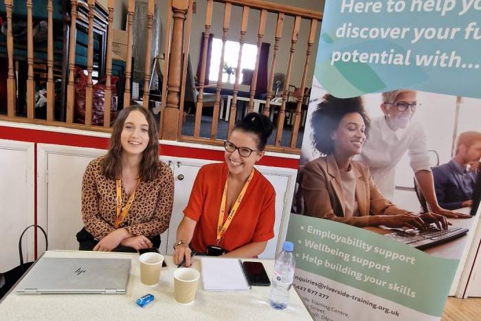 Two women sat behind a table 