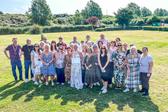 A group of people smiling in the sunshine