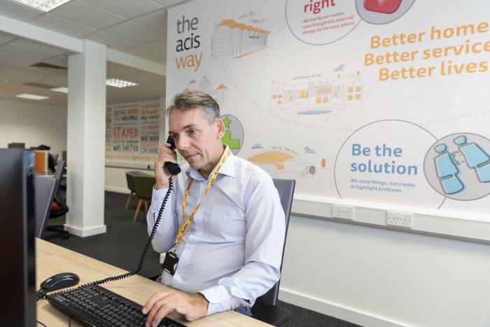 Acis employee sitting in front of computer on the telephone
