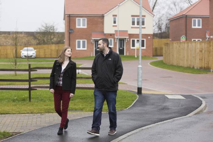 Two people walking through housing estate
