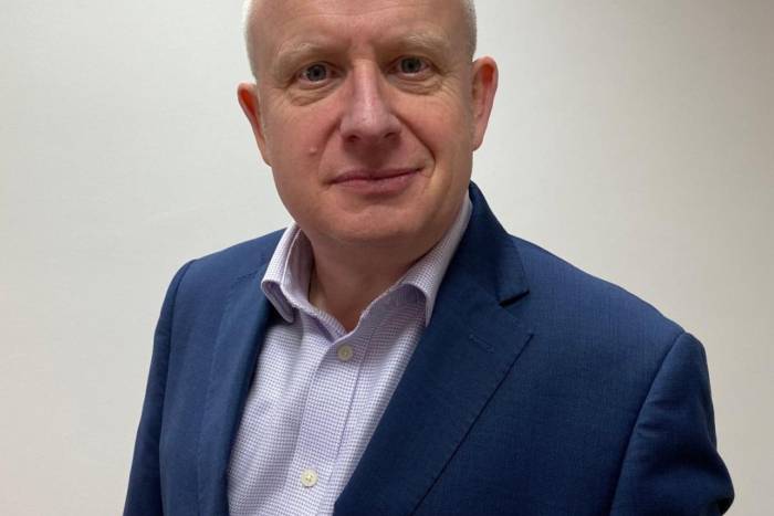 Headshot of Mark Jones in a blue suit and light blue shirt